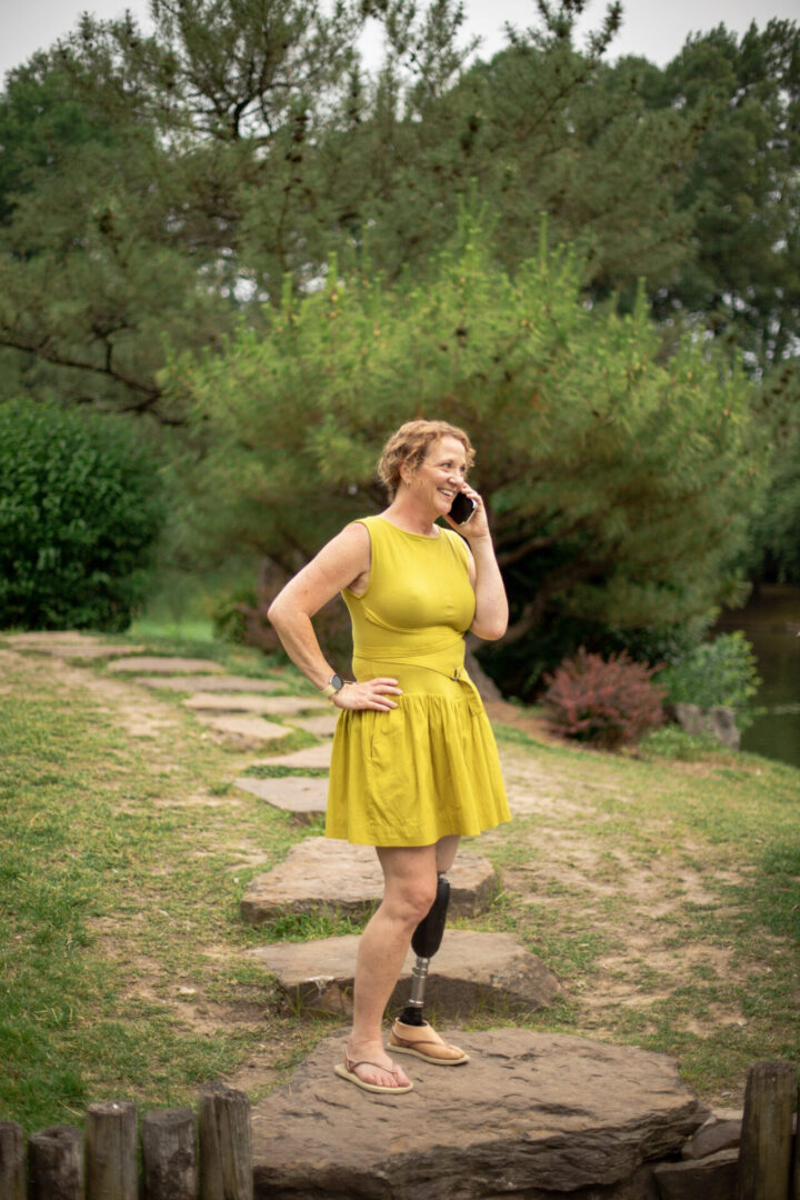 A woman in yellow dress talking on the phone.